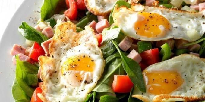 Salotos su kiaušinienė, špinatai, kumpiu ir pomidorais