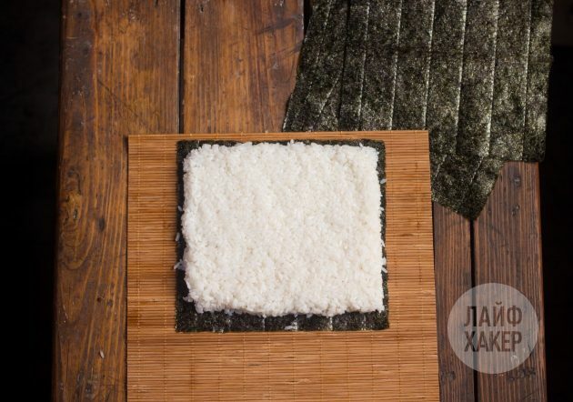 Kaip pasigaminti sushirrito: padėkite nori lapą ant kilimėlio ir padenkite jį ryžių sluoksniu