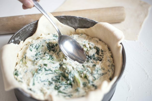 Itališkas sūrio pyragas: receptas. Tolygiai paskleiskite sūrio įdarą ir šaukštu padarykite tris įdubimus.
