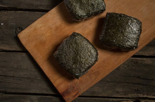 Onigirazu sandariai suvyniokite maistine plėvele, padarydami suši sumuštinių kvadratą