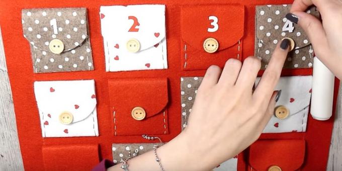 Advento kalendorius su savo rankas: Klijai sklendes ant kišenių ir mygtukų ir skaičiai